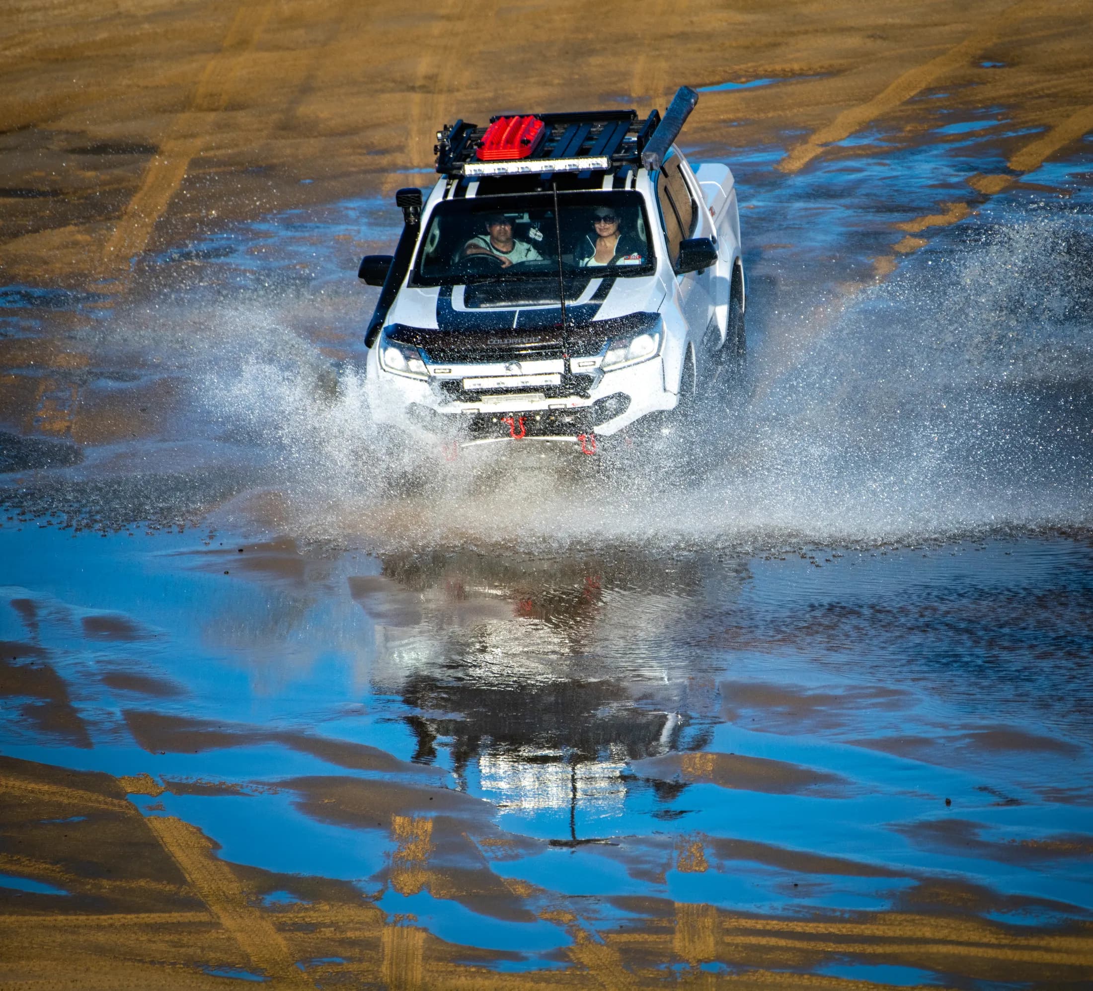 Four wheel drive crossing water with spray by Croome Photography